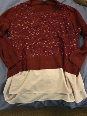 A Red Sweater With A White Undershirt Attached